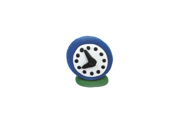 步骤2：捏十二个黑色扁圆和一大一小两个指针，并粘在表盘上。