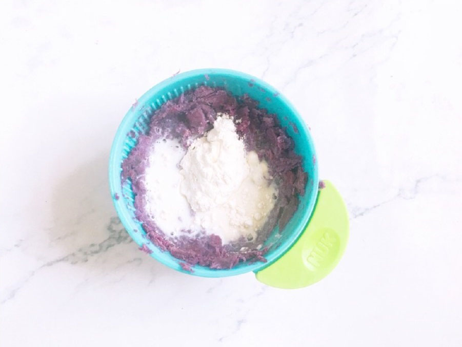 第5步：压好的紫薯泥中加入牛奶和面粉，搅拌均匀。