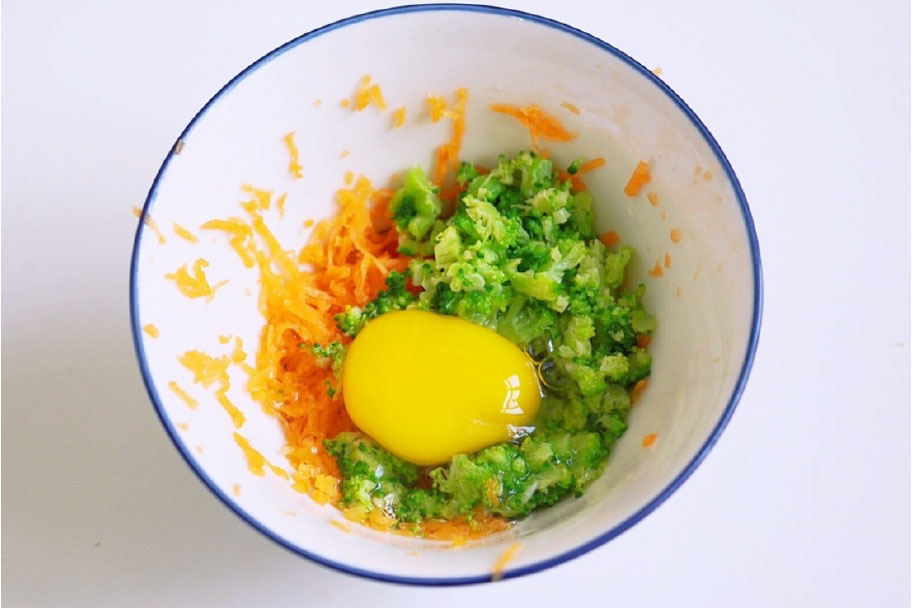 第8步：切好的胡萝卜和西兰花放入碗中，打一个鸡蛋，搅拌均匀。