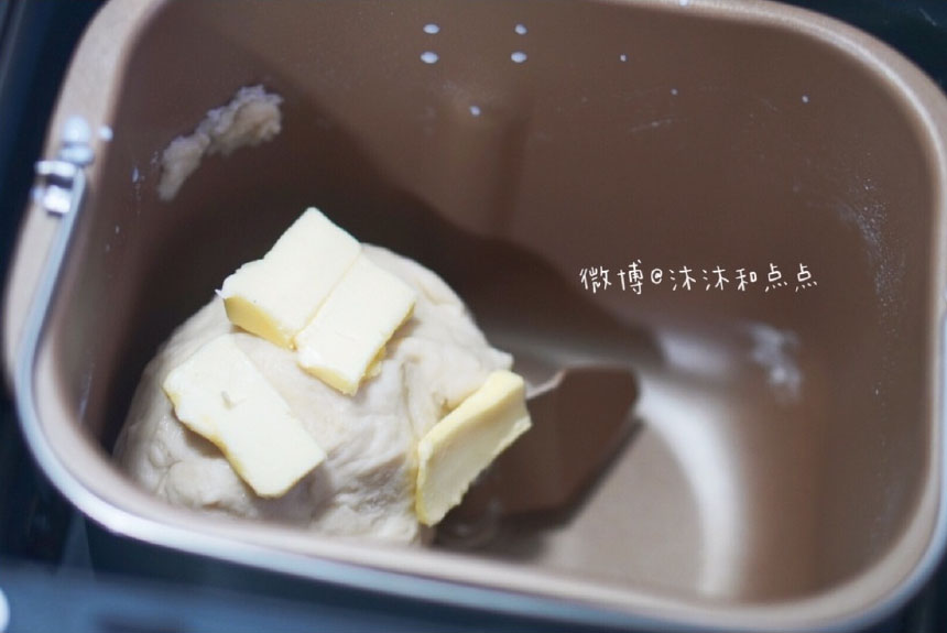 揉大概10分钟，面粉成团后，放入黄油，继续揉面。