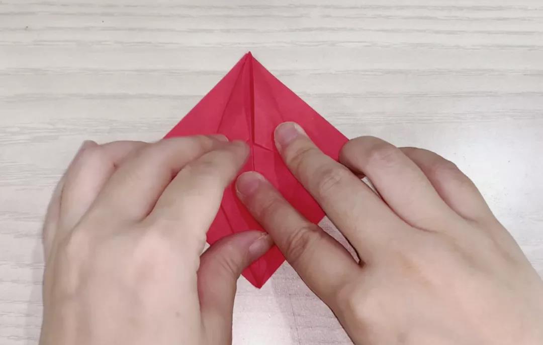 步骤4：接着开口处为顶端两侧也向中心折，再展开压平。