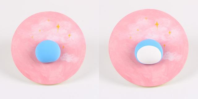 步骤2：取蓝色粘土做半球形粘在背景板中间位置，然后白色粘土做椭圆片粘在蓝色半球上，这是哆啦A梦的头部。