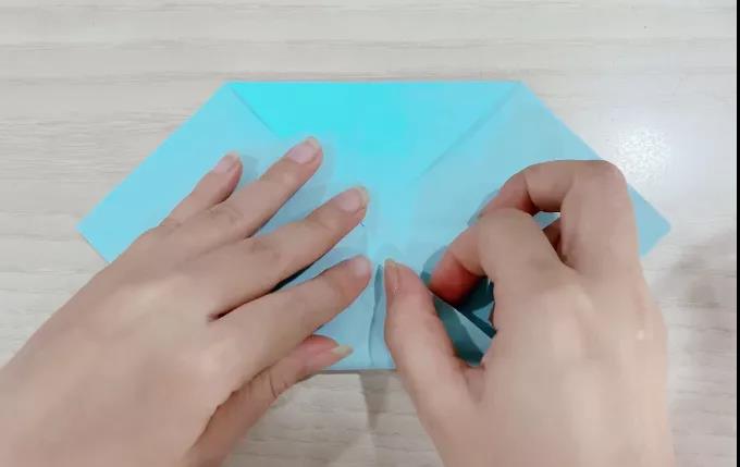 步骤2：对角两角向中心线折。