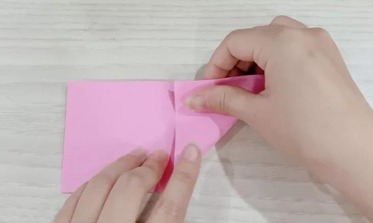 步骤1：正方形卡纸对折剪开后，取一半，中间对折后两边向中线折。