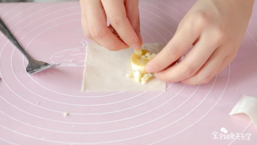 把香蕉和奶酪放到云吞皮里，对折包起来，稍微按压一下