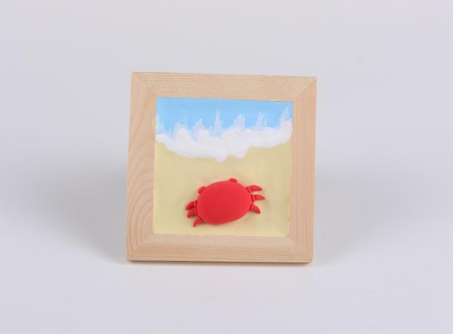 步骤6：用大红色粘土做出螃蟹的六只腿，分别粘在两边，上面要粘上两个小圆球准备做大钳子。