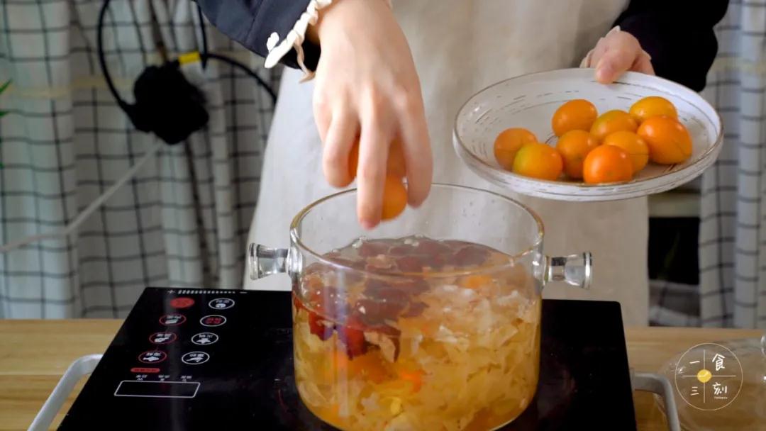 加入金桔和冰糖，煮至冰糖融化、汤水粘稠