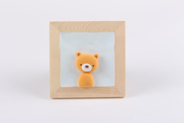 步骤4：然后用姜黄色粘土做出小熊的头和耳朵，用黑色粘土做出眼睛和鼻子，白色粘土做出嘴巴部分，如下图所示。