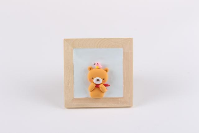 步骤7：然后用粉色粘土做一只小鸟粘在小熊的头顶。