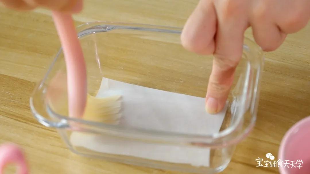 在玻璃模具中垫上一张油纸，刷上一层玉米油