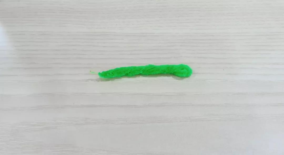 步骤1：两根绿色的扭扭棒对折后相互扭转在一起。