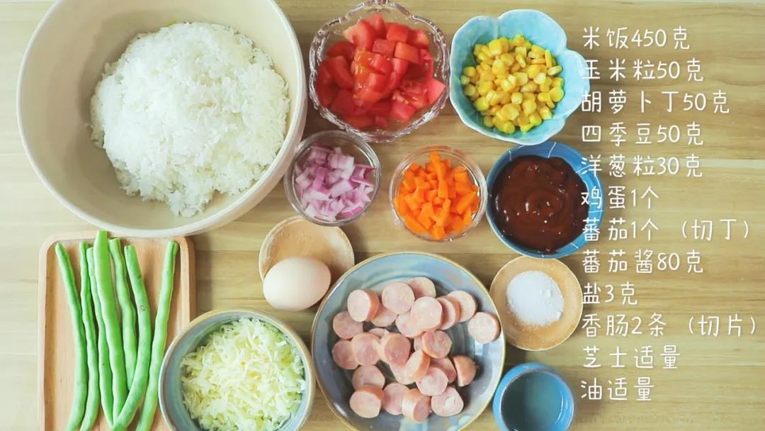 第1步：食材准备：米饭450克，玉米粒50克，胡萝卜粒50克，四季豆50克，洋葱粒30克，鸡蛋1个，蕃茄1个（切粒），香肠2条（切片），蕃茄酱80克，芝士、盐、油适量
