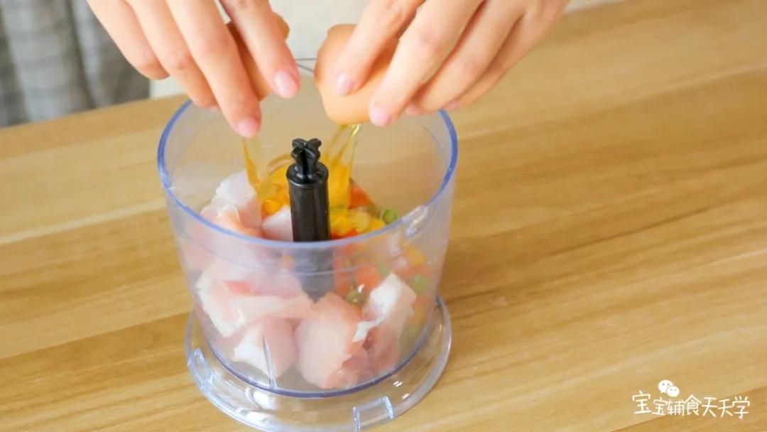 第3步：猪肉和杂蔬粒倒入搅拌机，打入一个鸡蛋，搅打成泥