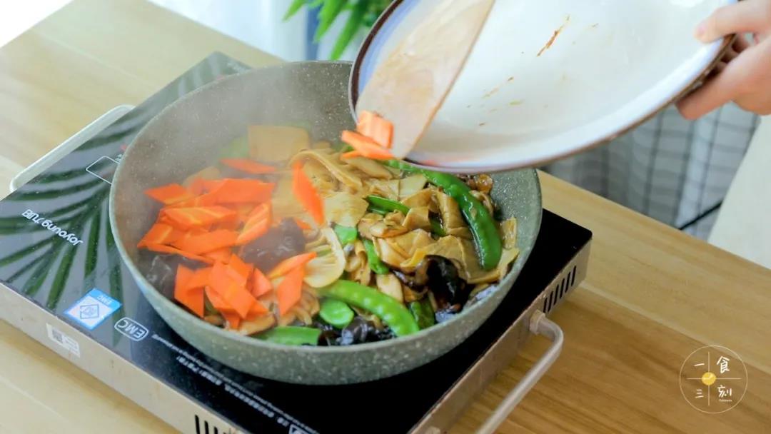 下入胡萝卜和适量盐，翻炒均匀