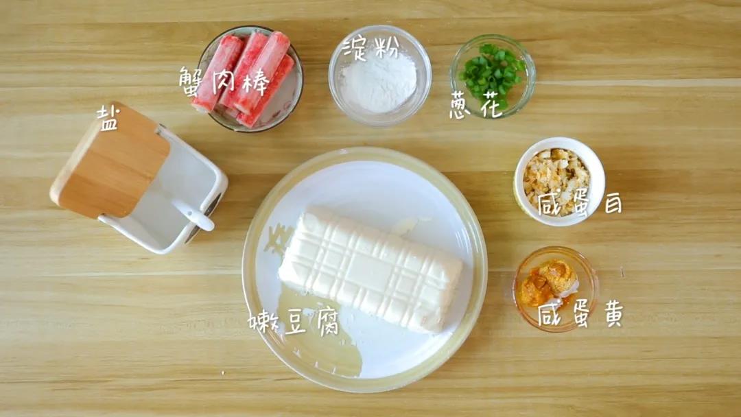 食材准备：咸蛋黄/2个，咸蛋白碎/半个，内酯豆腐/1盒，蟹肉棒/5根，玉米淀粉/5克，葱花、盐适量