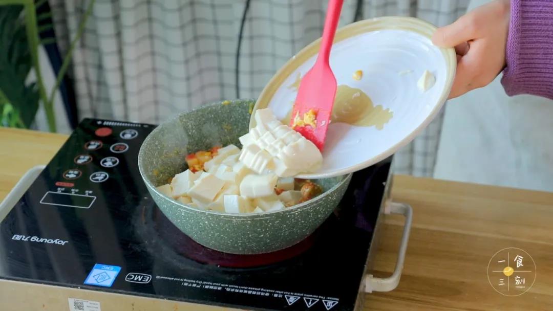 在蛋黄和蟹肉棒炒匀后加入豆腐、蛋白碎