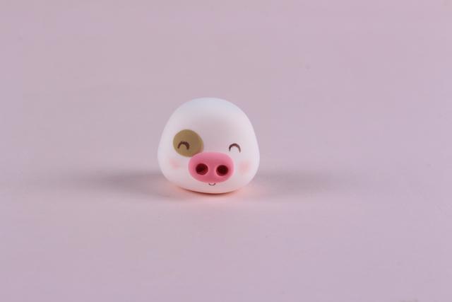 步骤6：用粉红色粘土做出麦兜的鼻子，褐色粘土做出麦兜的眼圈，然后画上眼睛和嘴巴，稍微涂一点腮红。