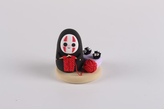 步骤8：用黑色和白色粘土做两只小精灵放在枕头上面。