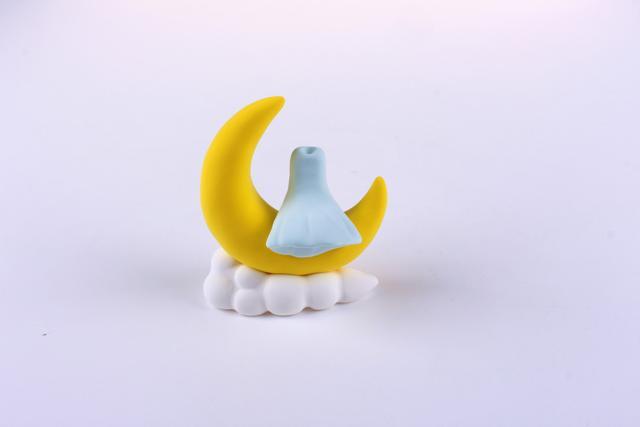 步骤6：用淡蓝色粘土做出女孩的身体部分，这是女孩的连衣裙，然后摆出坐姿粘在月亮上。