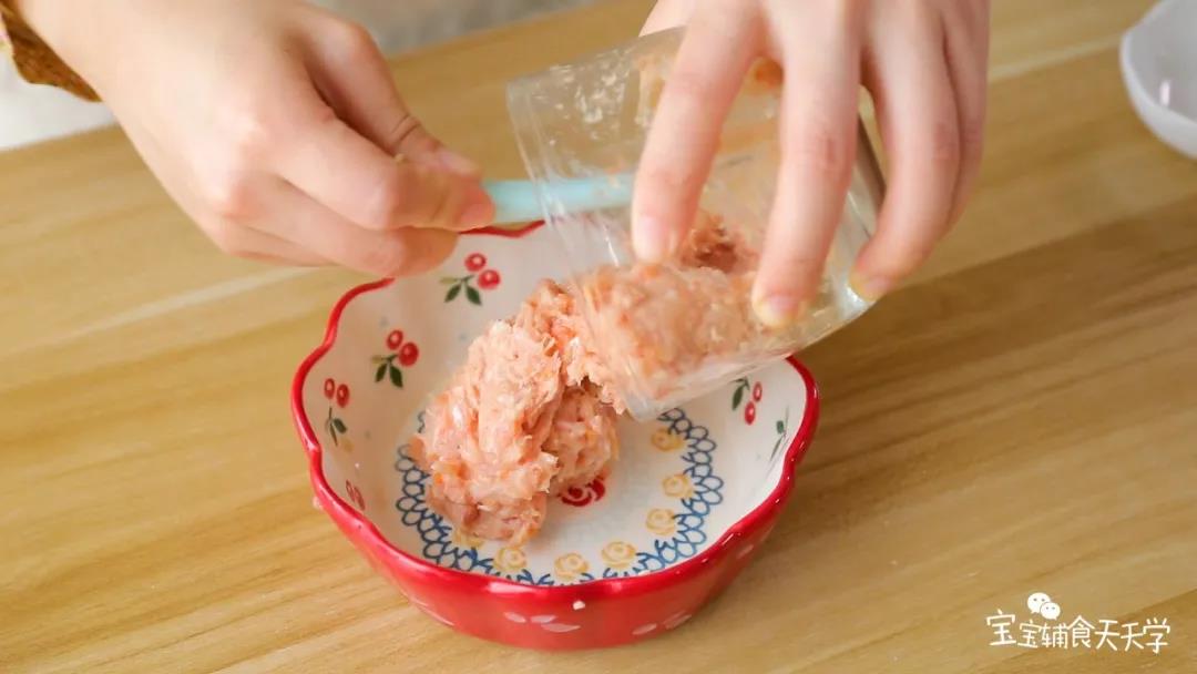 肉泥放入碗中，加入淀粉和玉米油后顺时针搅拌让肉泥起筋