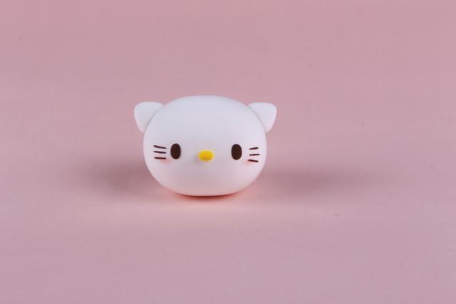 步骤2：然后白色粘土揉两个三角形耳朵粘好，黑色粘土做出眼睛和胡须，黄色粘土做出小鼻子。