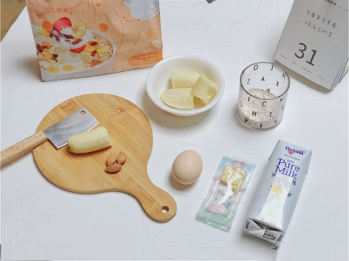 第1步：食材准备：香蕉60g（泥）15g（切片），牛奶100ml，鸡蛋1枚，奶酪适量，燕麦30g，坚果3颗，早麦脆适量。