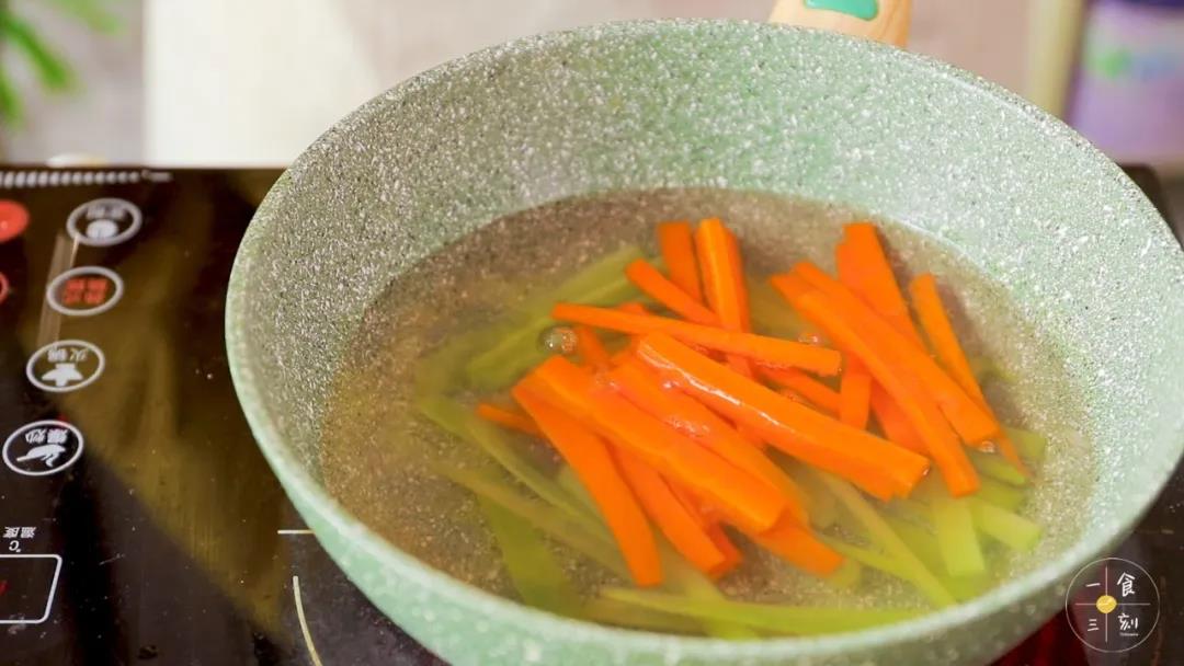 第5步：煮开一锅水，把胡萝卜条、莴笋条焯水，捞出沥干备用