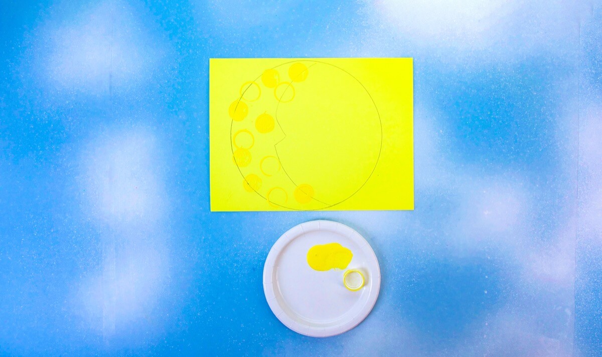 步骤5：要在月球上形成陨石坑，用瓶盖蘸上黄色涂料，然后将其盖在新月形上。您可以同时使用盖子的顶侧和底侧。干燥后，切出月亮形状。