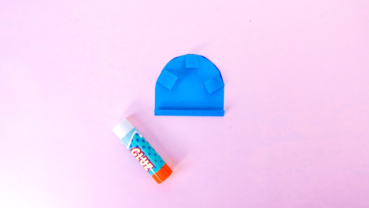 步骤11：要将末端固定在邮箱的背面，请切开并折叠三个纸舌，然后将其沿曲线边缘粘上。