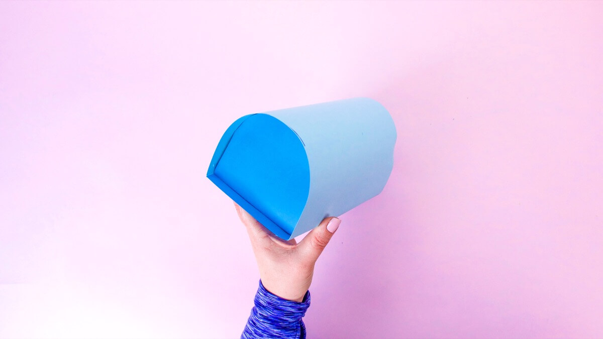 步骤12：将凸耳和折叠边缘的底部粘合到邮箱背面的内部，内部大约半英寸。从邮箱的另一侧用手固定住卡舌和边缘。