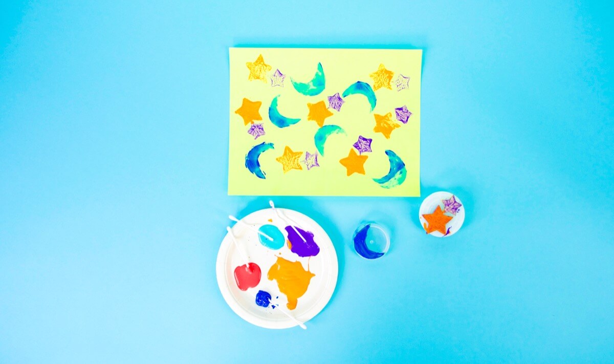 步骤3：使用棉签在彩纸上涂上颜色，并印上一些春季和夏季灵感的图案印花。(其他制作彩纸的方法包括：使用铅笔的笔尖进行圆点装饰，将绒球剪成衣夹，从马铃薯或苹果中切出有趣的形状，或将一些海绵修剪成有趣的形状。)