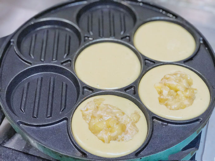 七孔锅预热，倒入半满的面糊，其中一个上面放上香蕉奶酪，待松饼糊上面冒大泡，就盖在有馅料的上面。这个一定不能着急，开始我总怕糊，结果失败了。然后翻个面等个两三分钟就可以了。