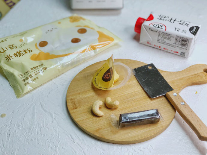 食材准备：米糕粉100g，牛奶110g，山楂条适量，奶酪1-2g，坚果（腰果）2颗。