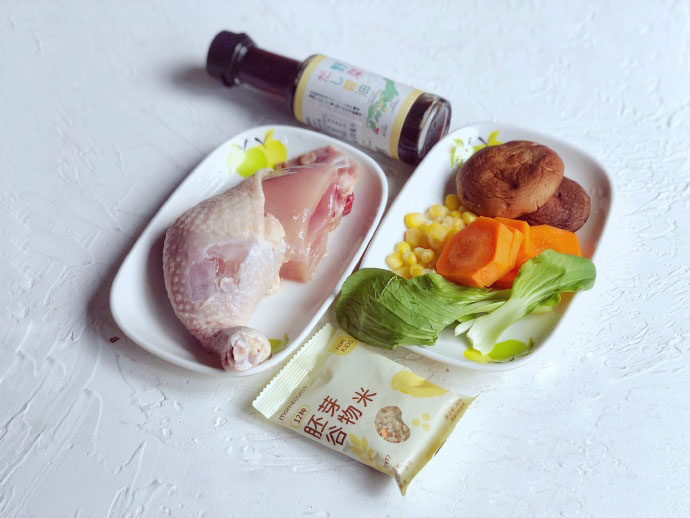 食材准备：​鸡腿肉30g，胚芽谷物米1包，油菜5g，胡萝卜10g，香菇2朵，玉米粒10g，宝宝酱油适量