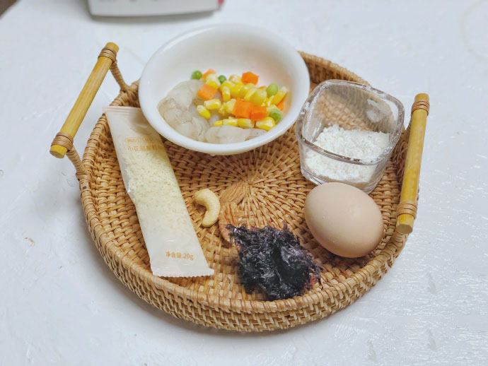 第1步：食材准备：​粒粒面一包20g，虾仁3个，冷冻时蔬适量，面粉5g，坚果3颗，头水紫菜适量，鸡蛋1枚。