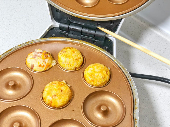 第4步：小白锅预热，丸子烤盘撞上刷油。之后舀上糊糊，盖上盖子五分钟，翻一番出锅。用签字穿好就可以了。