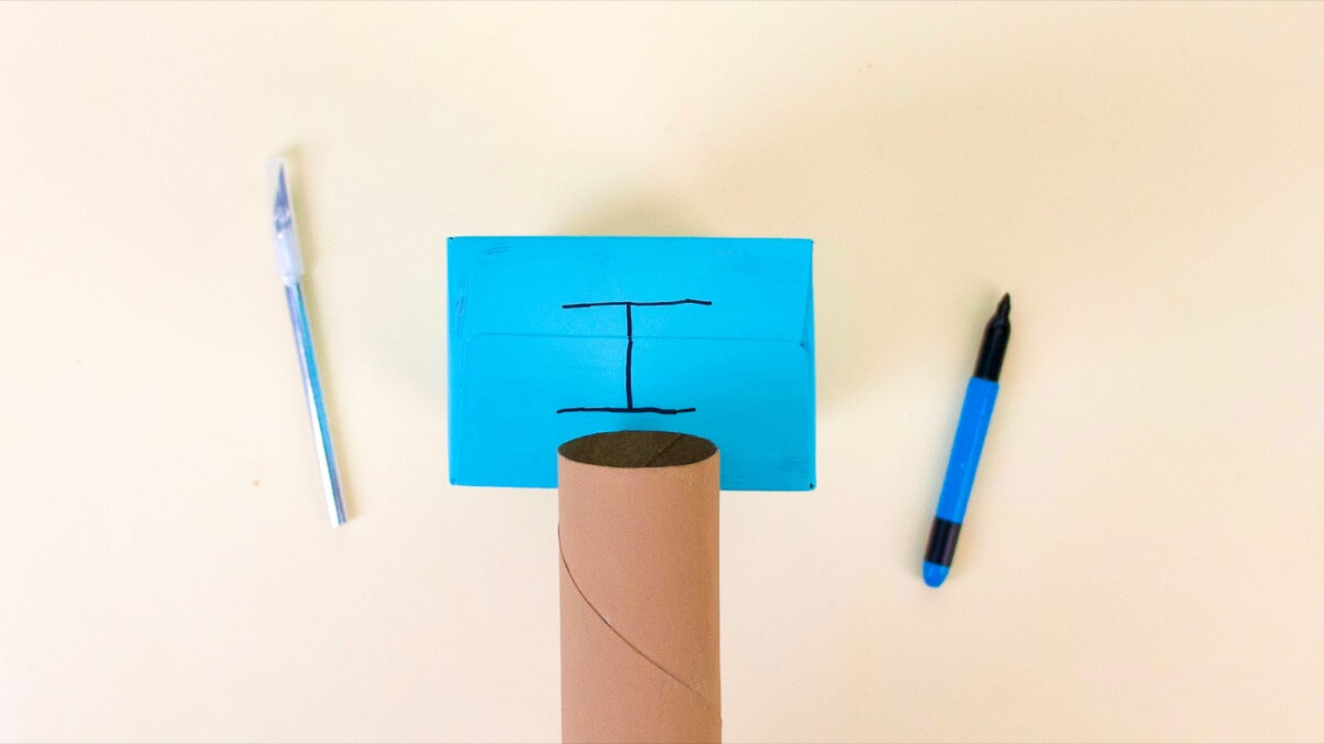 步骤2：将硬纸板管的端部固定在吉他琴体的侧面，并画出两条与硬管端部相同的宽度的平行线，但比硬管的宽度稍微靠近一点。