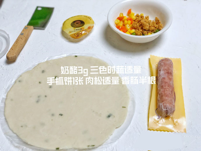 食材准备：手抓饼1张，宝宝香肠半根，三色时蔬适量，肉松适量，奶酪3g。