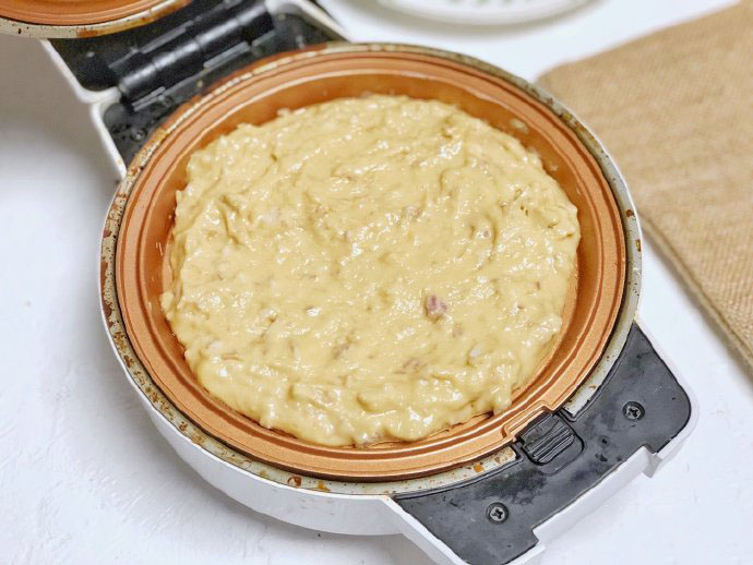 第4步：平底锅刷油，将芋泥糊糊倒入锅里，尽量抹平。盖上盖子五分钟，看看上的情况翻面，再2-3分钟。两面微微金黄，饼微微变大。就熟了。