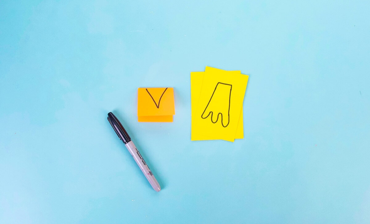 步骤5：取一个棉球，将其浸入白色手工艺漆中。将油漆压入企鹅腹部的中央。然后将心形印在脸部头部上。