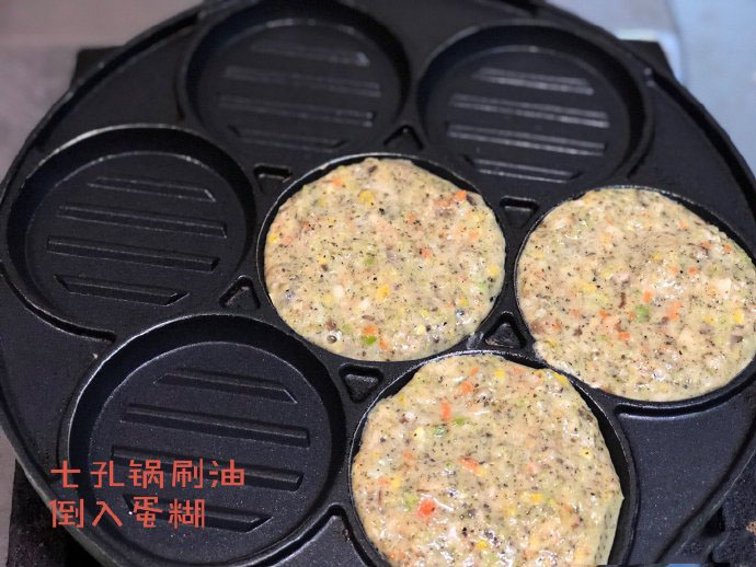 七孔锅刷油，将蛋糊倒入锅里，两三分钟，蛋饼表面微微凝固翻面。再煎一分钟就可以出锅了。