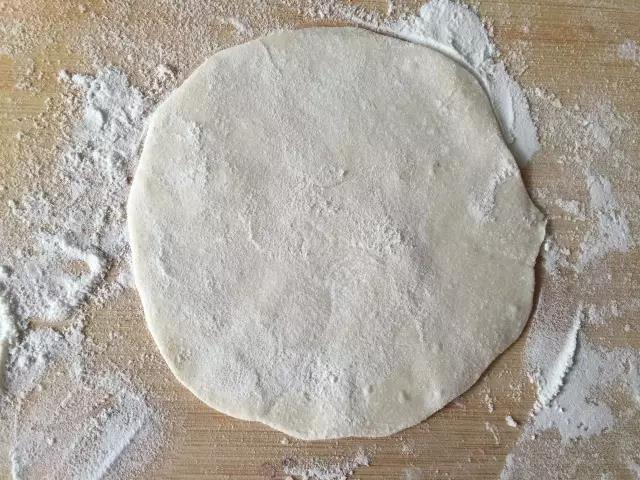 用擀面杖擀成圆形面片。
