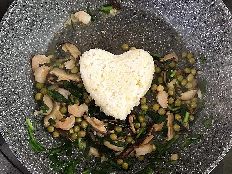 米饭放入锅中，用锅铲打散。