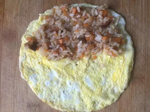 米饭盛到蛋皮上，对折起来就可以吃了。