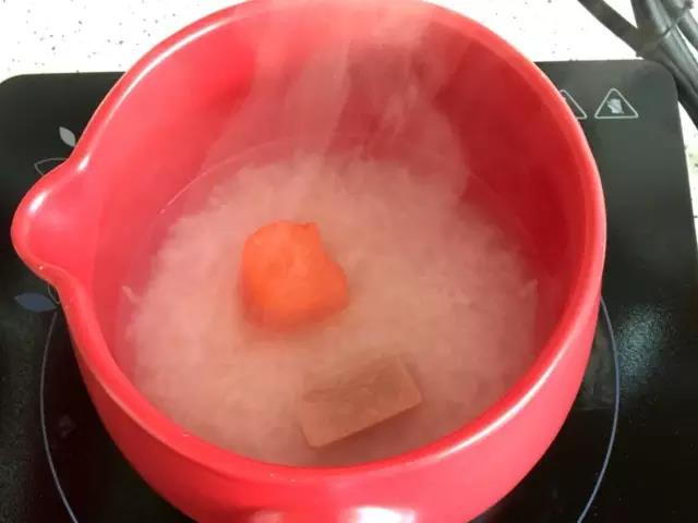 大火煮开后小火煮，米粒开花时放入胡萝卜和猪肉泥。