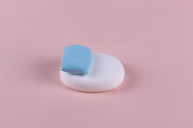 步骤2：用蓝色粘土做一个枕头放在小床一端。