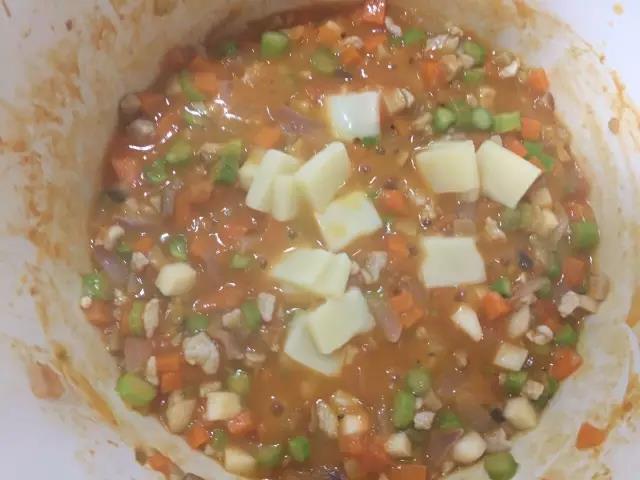 加少许水，放入奶酪，小火加盖焖至奶酪融化。最后盖在米饭上即可。