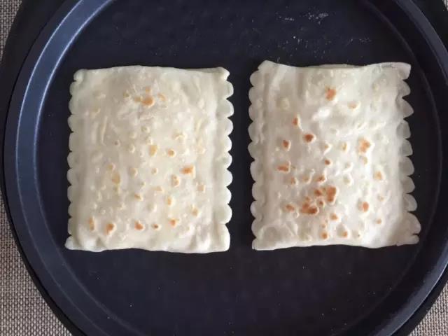 电饼铛预热，不抹油直接放饼，烙的过程中往饼上刷油，两面都刷，烙至两面金黄。装入蔬菜。