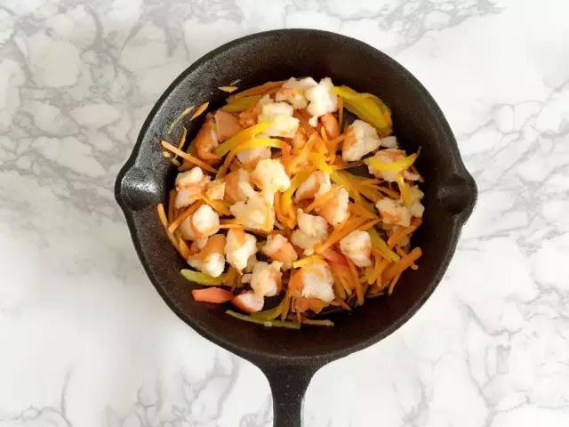 锅烧热后刷层油，依次倒入虾仁、胡萝卜、红黄彩椒煸炒软。