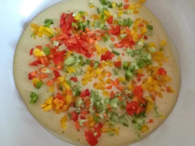 锅内刷层油，面糊倒入锅内，摊平，成形后铺上蔬菜碎。